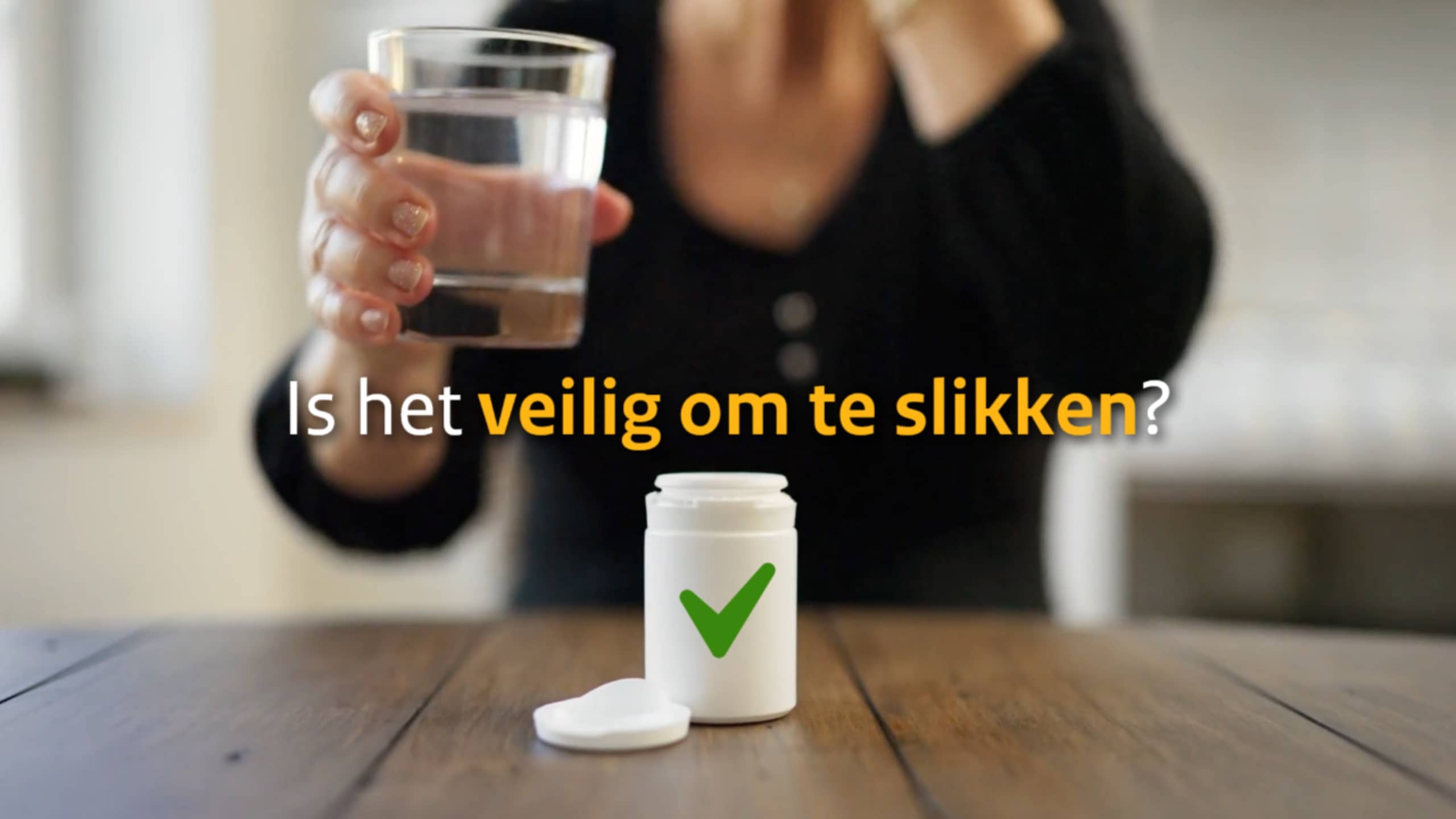 Vrouw aan tafel opent medicijnpotje terwijl tekst "Is het veilig om te slikken?" verschijnt