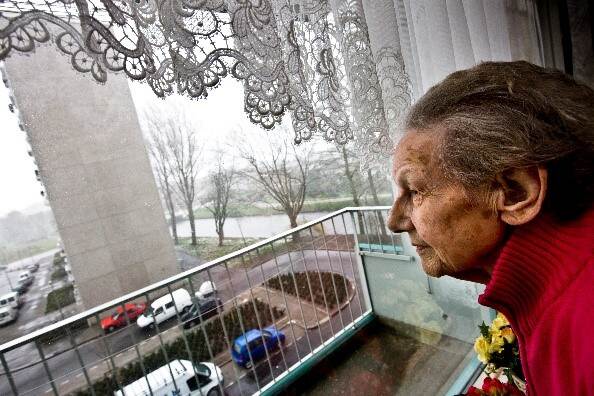 Bewoonster Utrecht-Overvecht kijkt uit het raam van haar flat