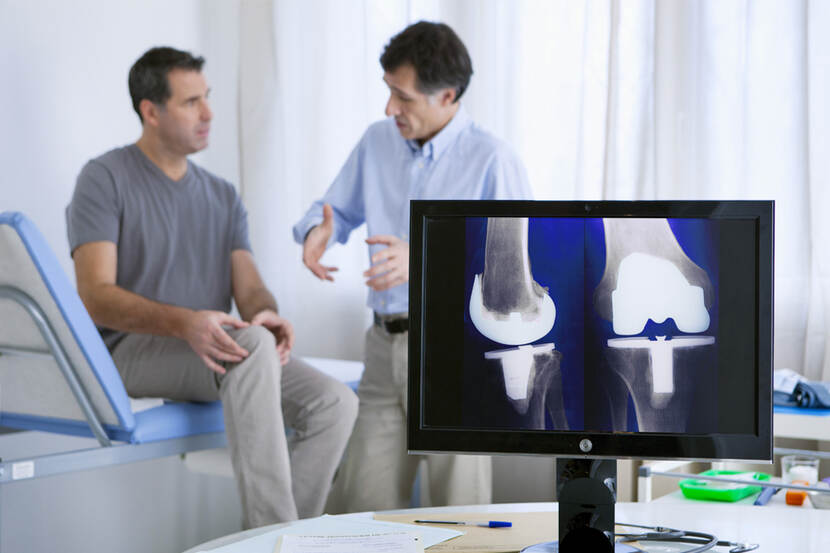 Zorgverlener geeft patiënt uitleg over knieprothese